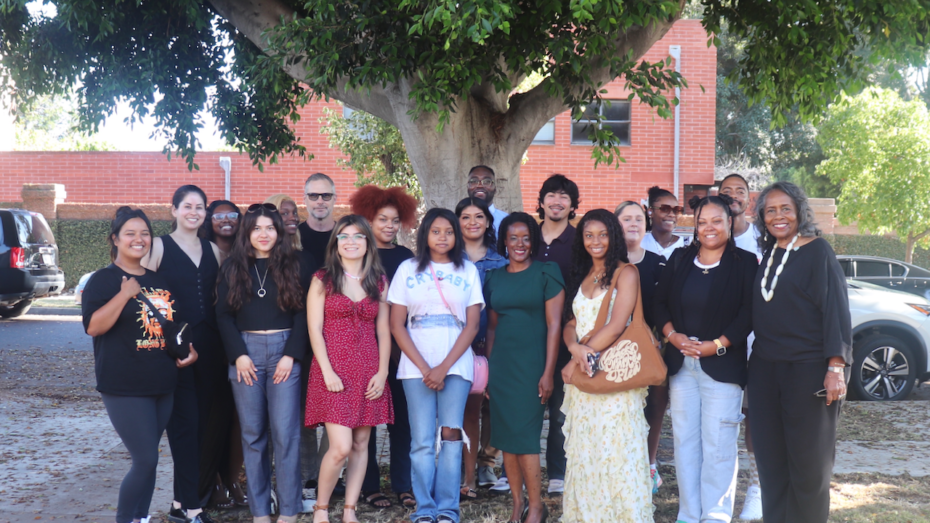 A multiethnic, multi-aged group of people who have received the Biddy Mason Charitable Foundation scholarship are assembled under a tree.